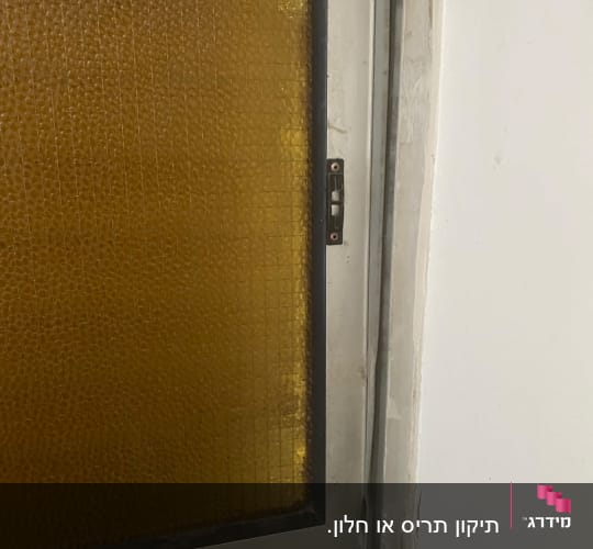 חלון עם זכוכית צהובה במסגרת מתכת